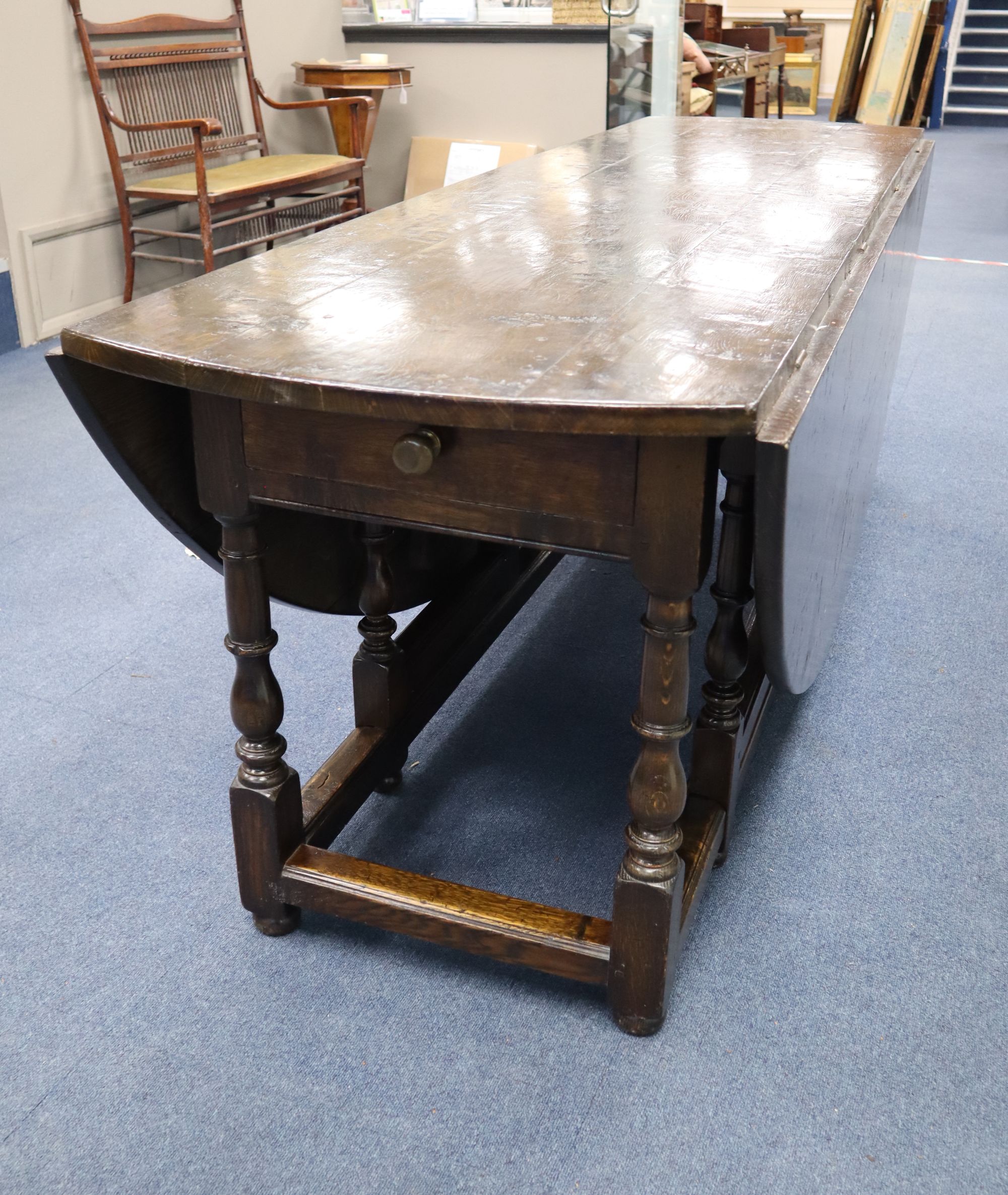 A late 17th century style oak oval topped, double gate leg dining table, width 214cm depth 180cm (extended) height 75cm